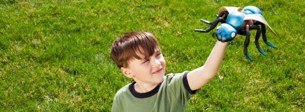 A child with a bug toy playing outside in his front yard in Indiana