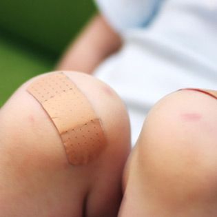 Close-up of a child's knees with bandages in Chicago and Rockford.
