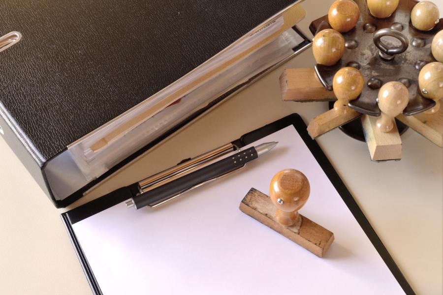 Stamped roundel with folder on desk and paper stamp and clipboard