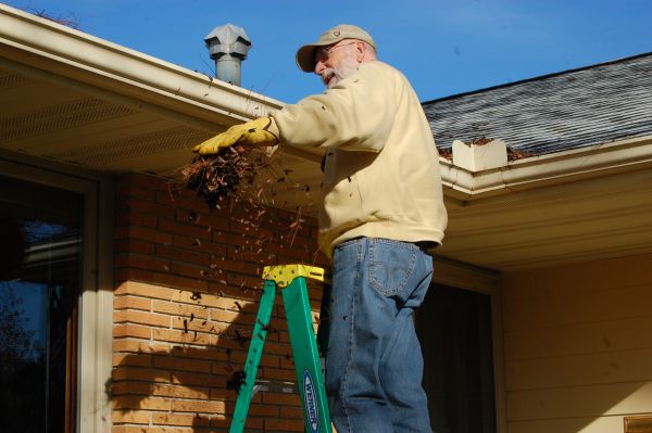 A man is cleaning the gutter at the residence located in the Chicago and Rockford areas.